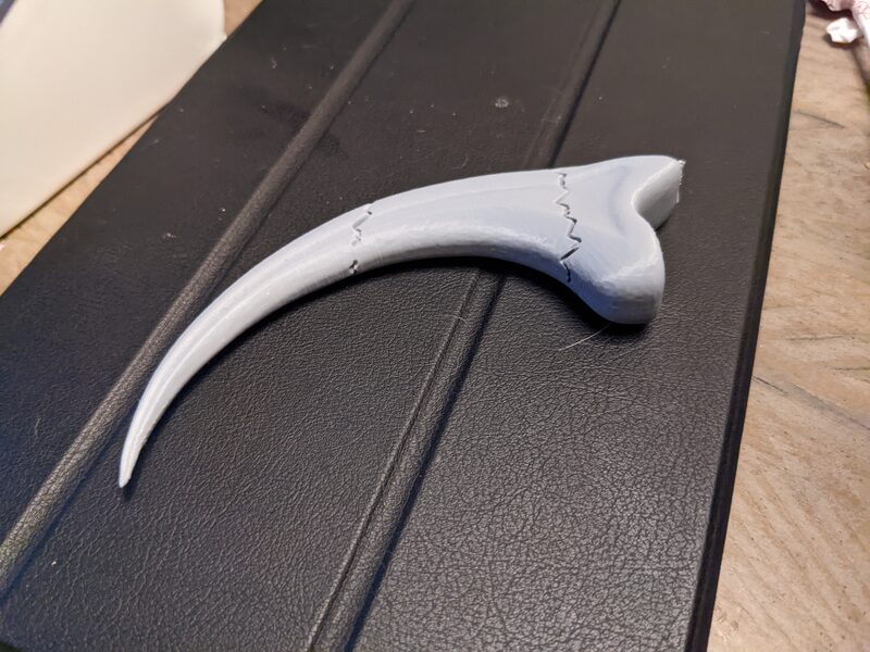 A 3D printed Jurassic Park raptor claw, raw and unpainted