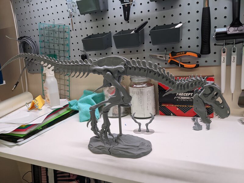 The finished T-rex skeleton mounted on a display base on the workbench