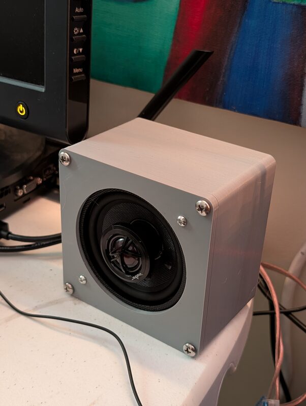 A gray 3D printed speaker enclosure housing a Skar-branded speaker