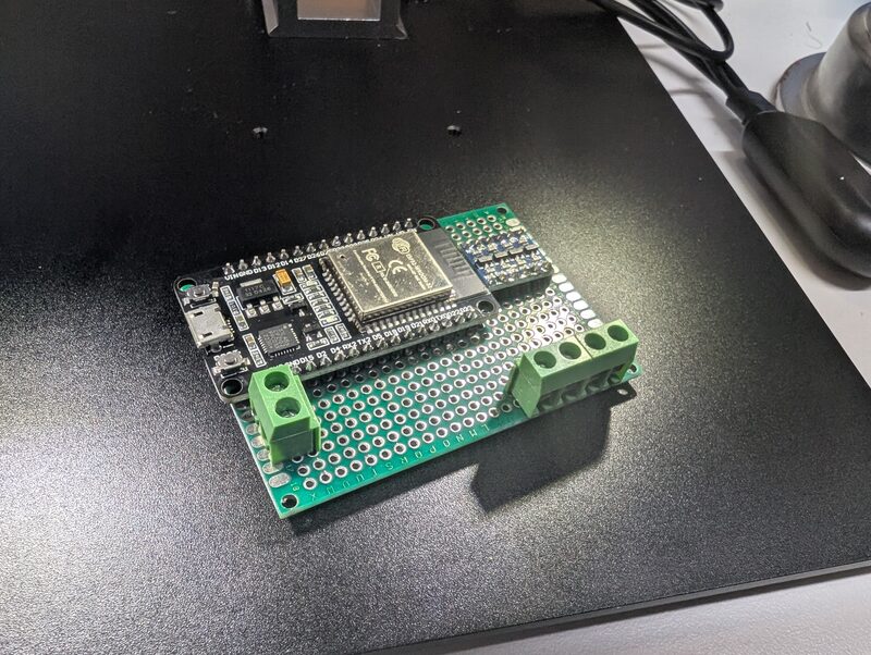 An ESP32 development board mounted on a custom proto shield with screw terminal blocks