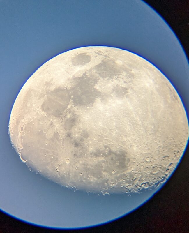 A gibbous moon against a blue evening sky