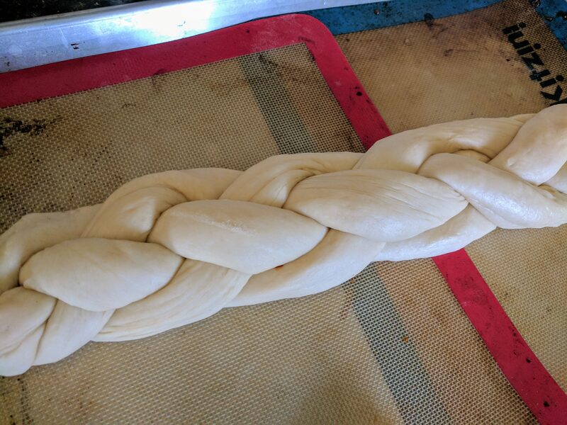 A braided loaf of dough, proofed and ready for the oven