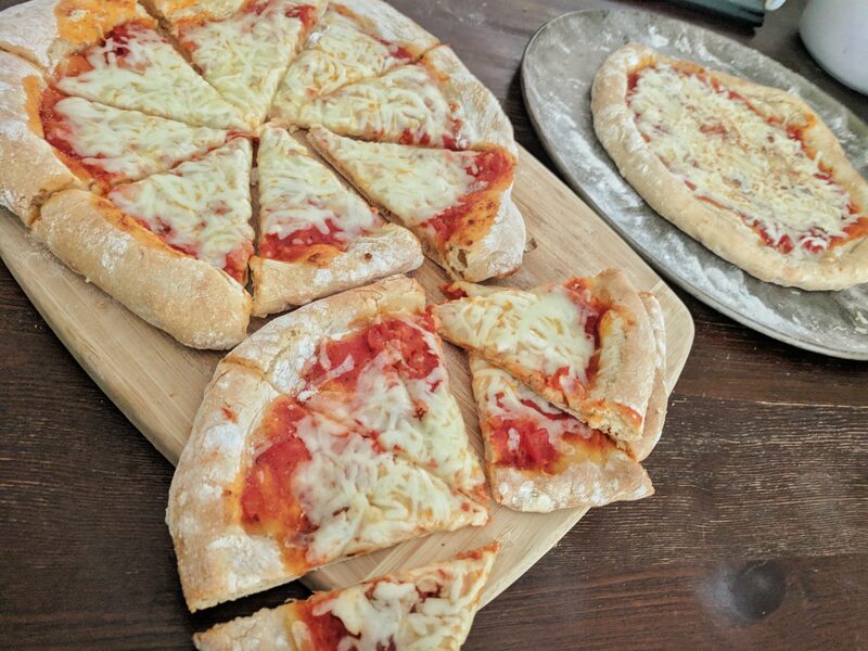 Homemade cheese pizzas, sliced, with a thick hand-formed crust