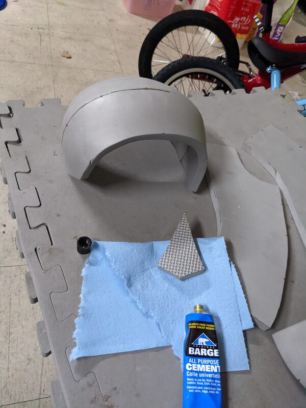 The cut foam pieces cemented together into a rounded helmet shape, next to a tube of Barge cement