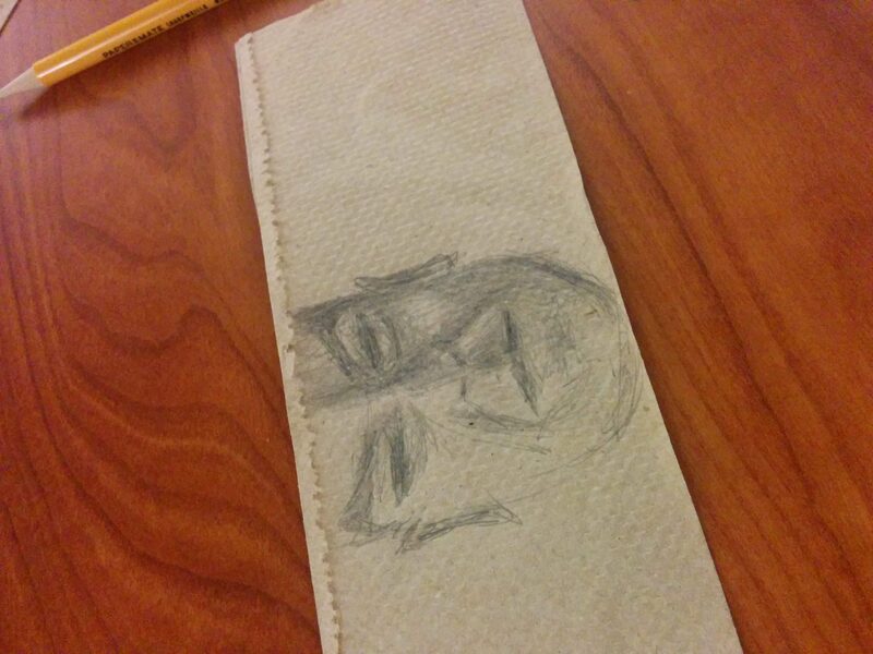 A quick pencil sketch of a face, drawn on a torn strip of paper towel