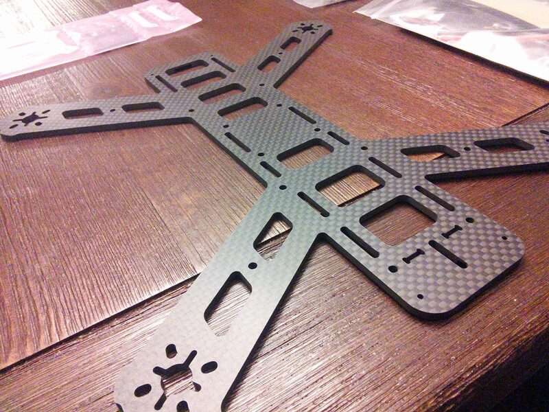 A bare carbon fiber X-frame for the racing drone, fresh out of the packaging