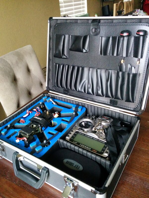 A hard case with custom-cut foam holding the finished drone, the FrSky Taranis radio, and tools