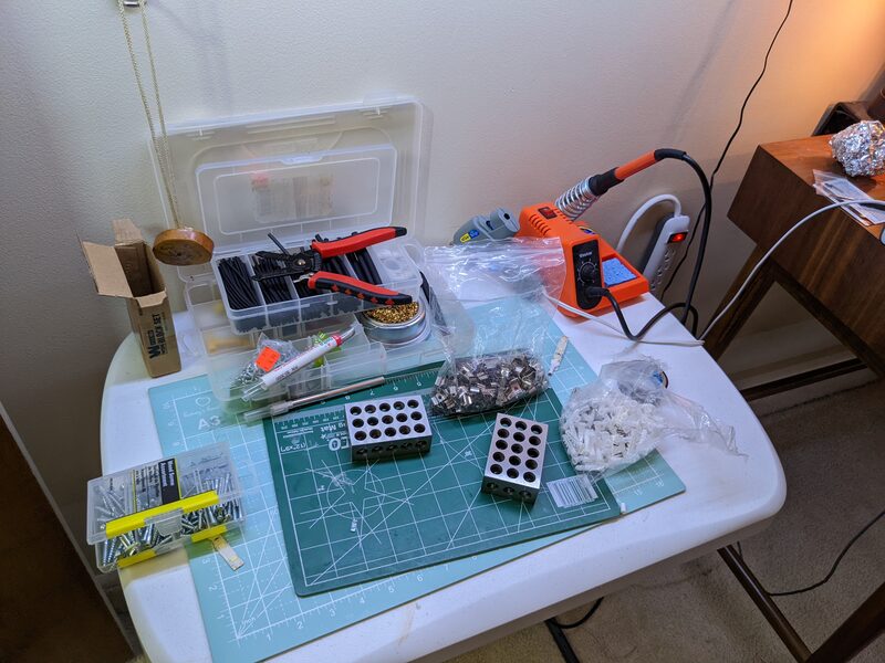 A basic soldering station setup with heat shrink tubing, wire strippers, solder, and small parts organized in bins