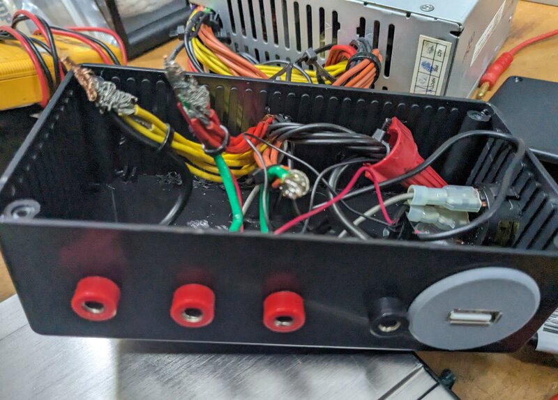 The inside of a modified PC power supply case, wired with binding post connectors and a USB port to break out 3V, 5V, and 12V rails