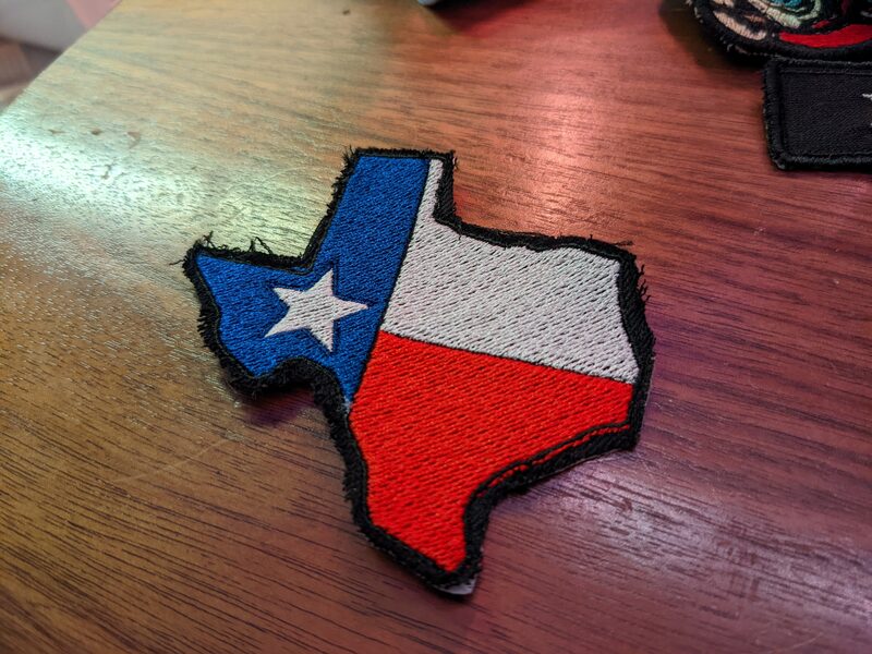 A finished Texas flag-shaped embroidered patch