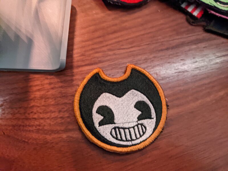 A round Bendy character patch, black and white with an orange border
