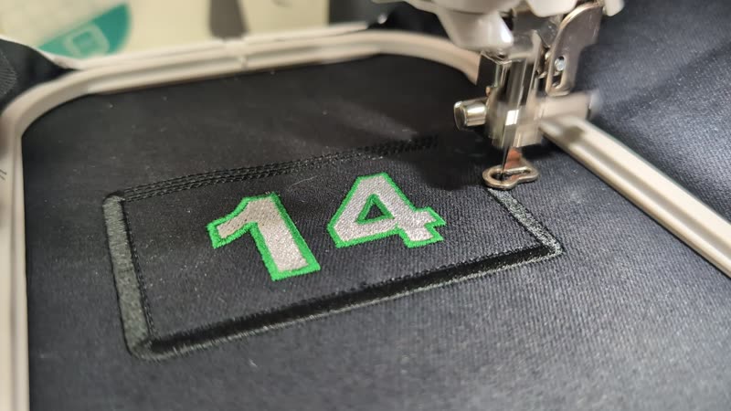 Video still of the embroidery machine stitching the jersey-number patch