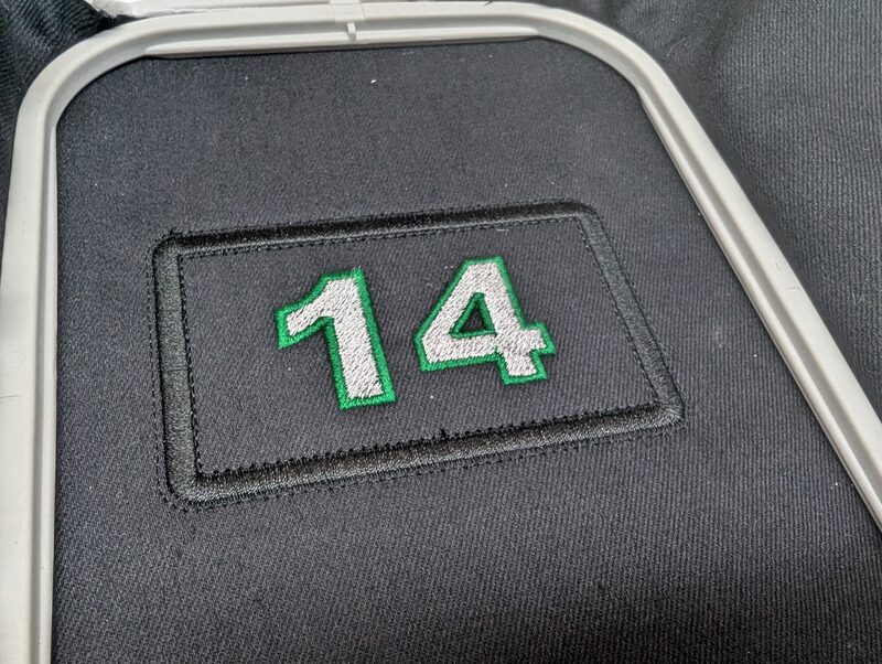 A hat patch with the number 14 stitched in green and white