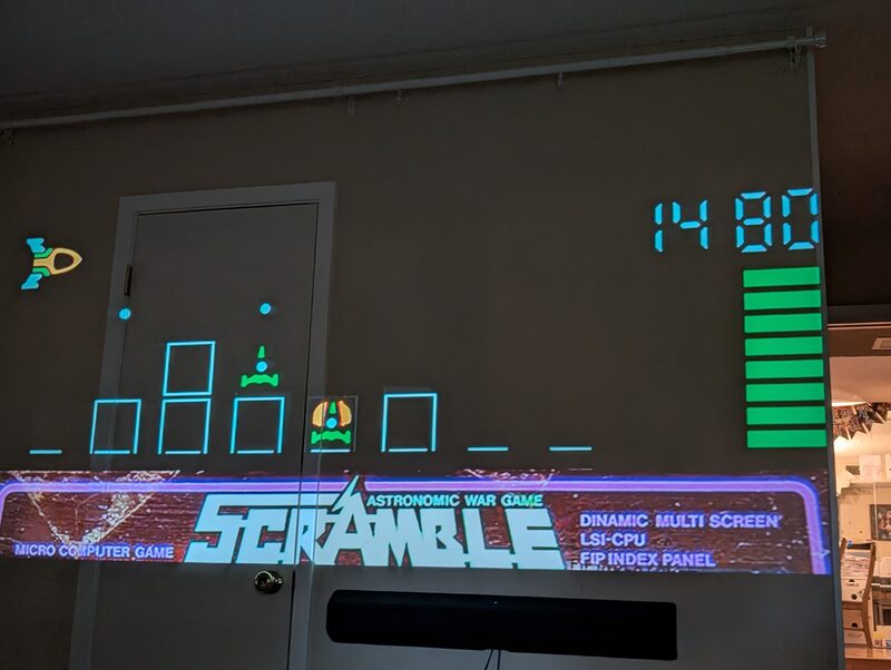 The arcade game Scramble projected large on a wall and door