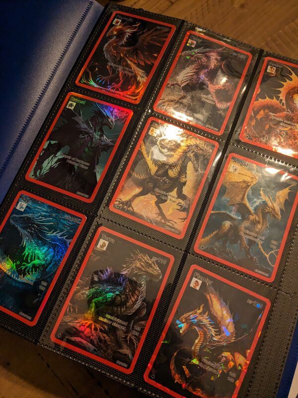 A binder page full of the finished holographic dragon trading cards