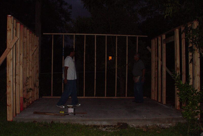 My grandpa and me anchoring the framed walls of a backyard shed to its concrete foundation at night, after an all-day-and-all-night build
